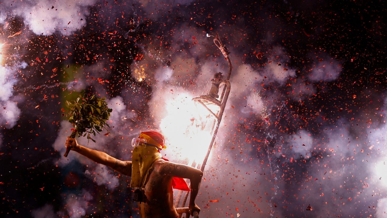 A volunteer is pelted with exploding firecrackers as part of the Lantern Festival celebrations in Taitung