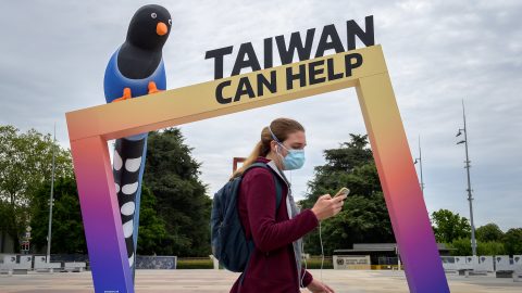 A woman walks by an arch reading “Taiwan Can Help” next to the United Nations Offices in Geneva on the opening day of the World Health Organization’s World Health Assembly on May 24, 2021. (Photo: Fabrice Coffrini/AFP)