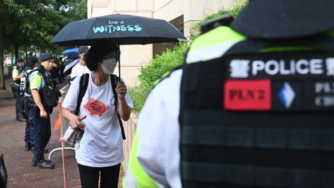 Police watch people entering the West Kowloon Magistrates' Court in Hong Kong on July 5, 2024, where pro-democracy activist Joshua Wong and five others appear in National Security Law trial. (Photo by Peter Parks/AFP)