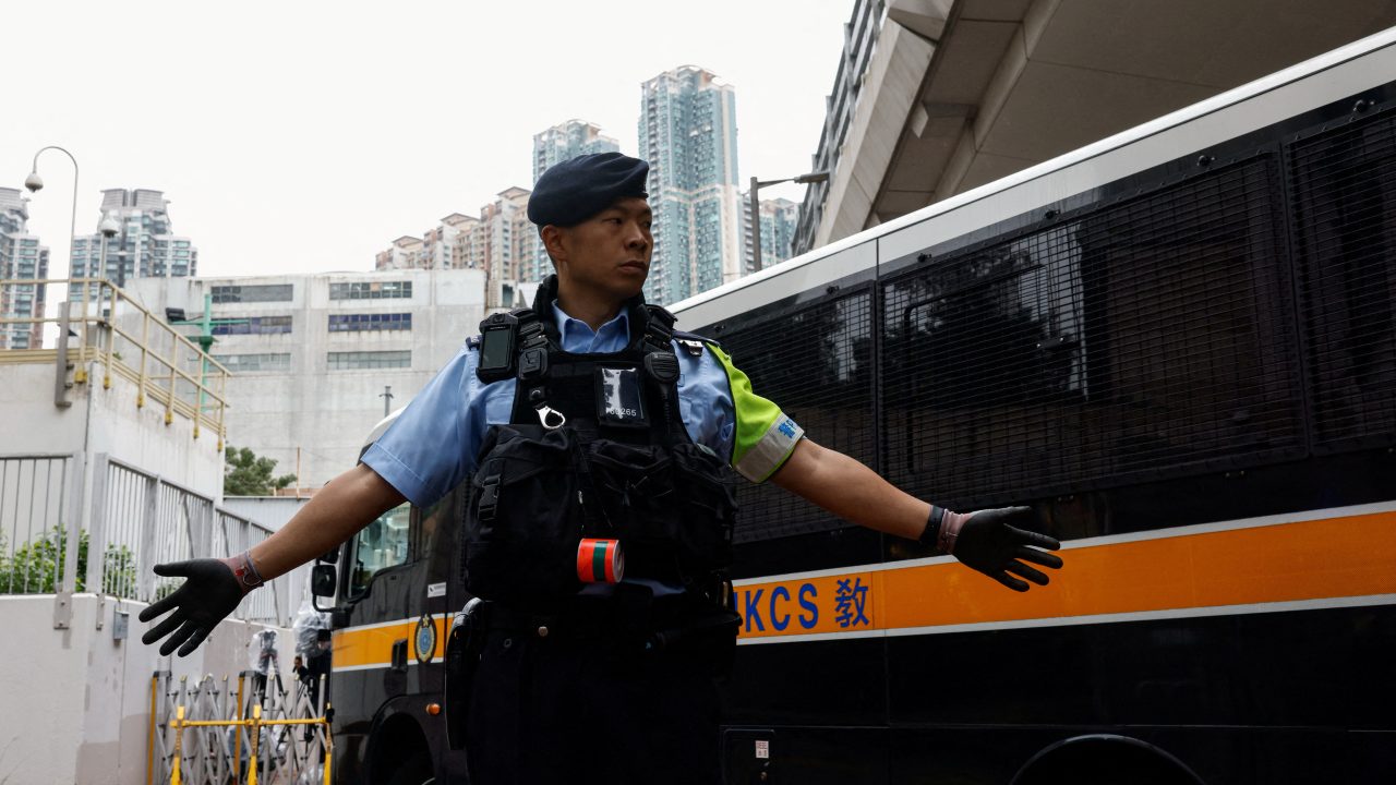 A police officer stands guard as a prison van arrives at the West Kowloon Magistrates’ Courts building ahead of the sentencing of 45 pro-democracy activists charged under the national security law in Hong Kong on November 19. (Photo: Tyrone Siu/Reuters)