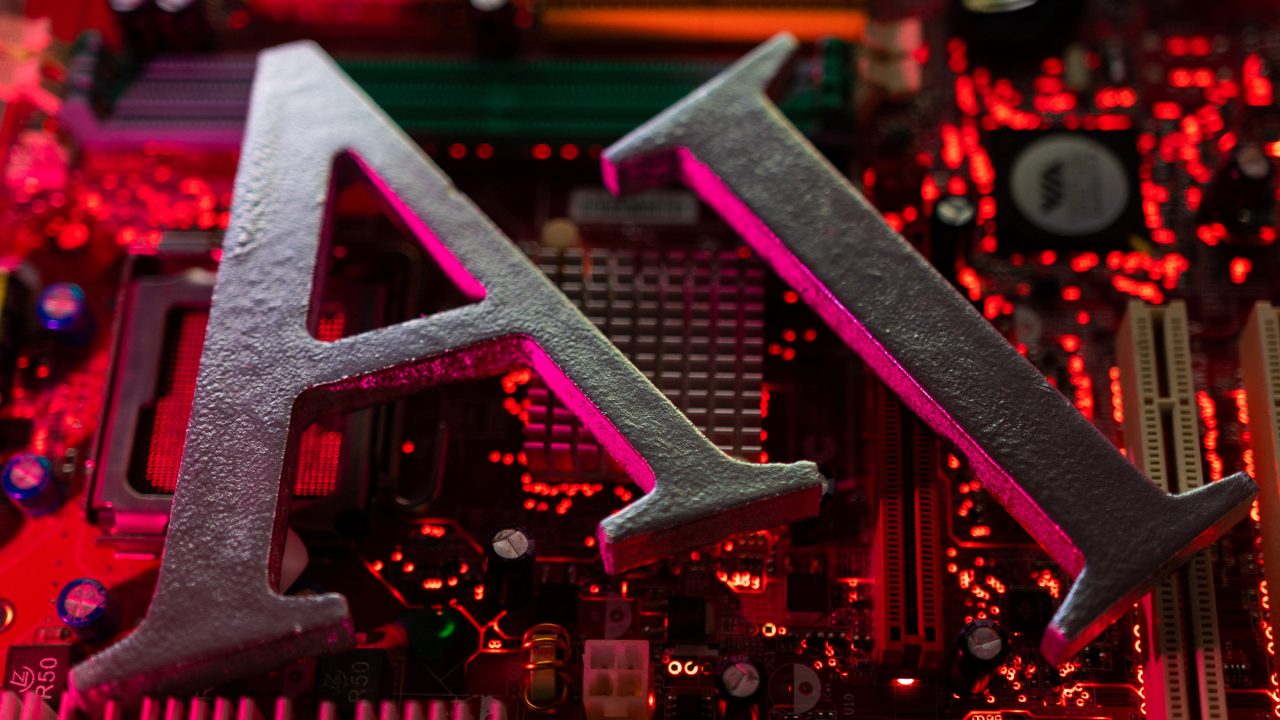 Illustration shows AI Artificial Intelligence letters and computer motherboard