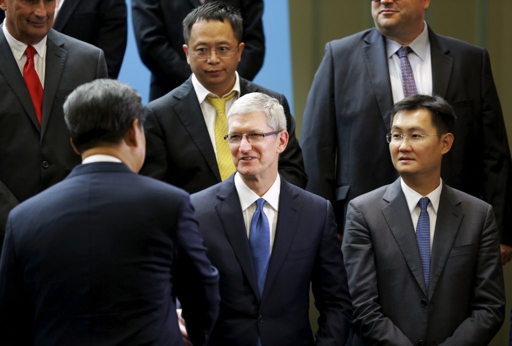 Chinese President Xi Jinping shakes hands with Apple Inc CEO Tim Cook as Tencent CEO Pony Ma looks on during a gathering of CEOs and other executives at Microsoft s main campus in Redmond Washington