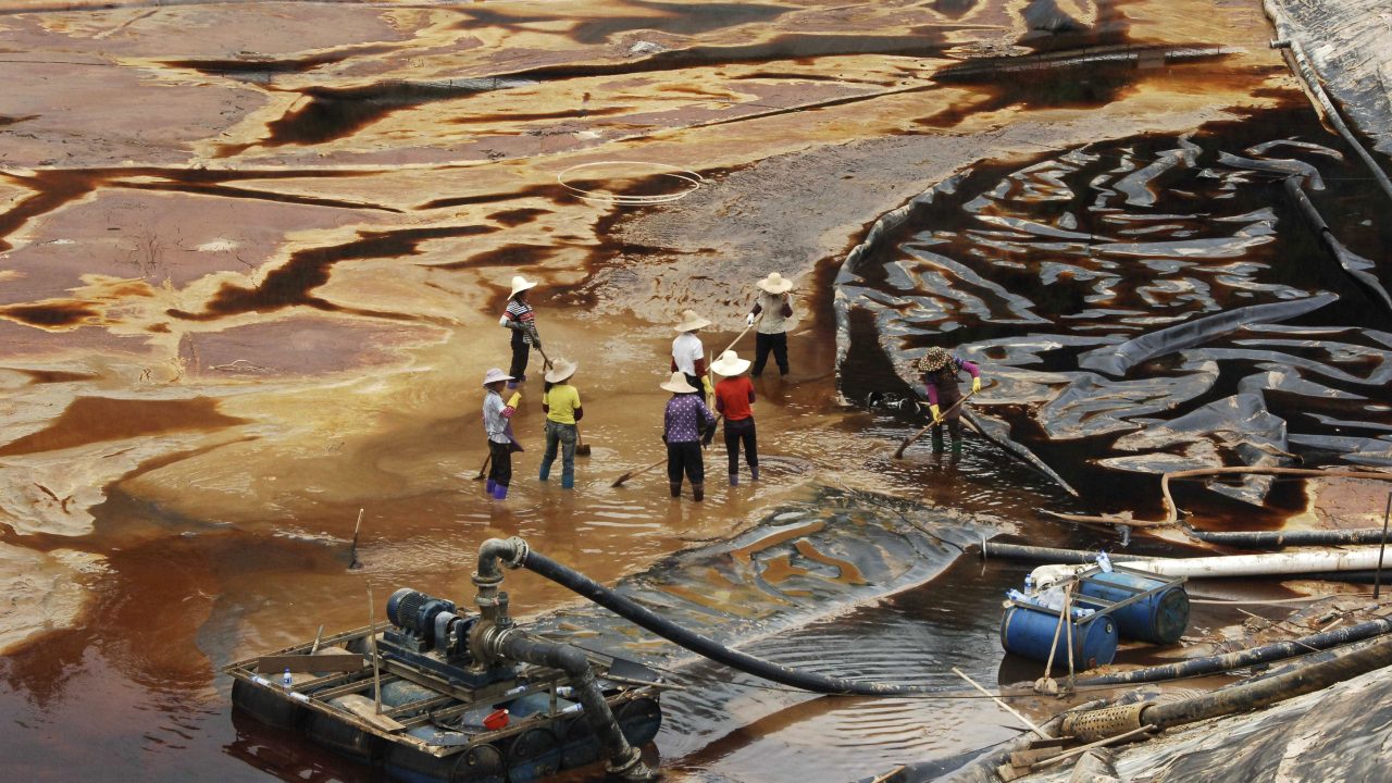 Laborers work to drain sewage water from a leaked sewage tank at a copper mine in Shanghang County in China’s Fujian Province in July 2010. (Photo: Reuters)