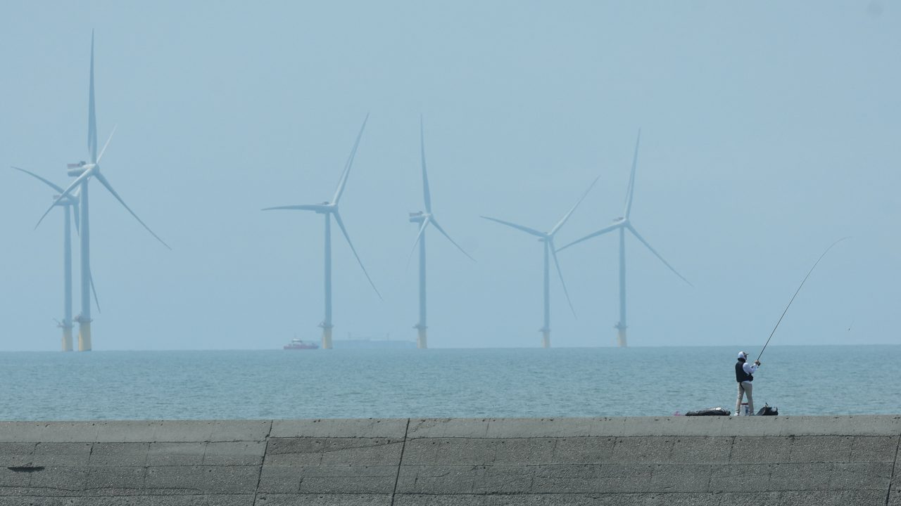A man fishes near a wind farm in Yunlin County on March 4. (Photo: Ann Wang/Reuters)