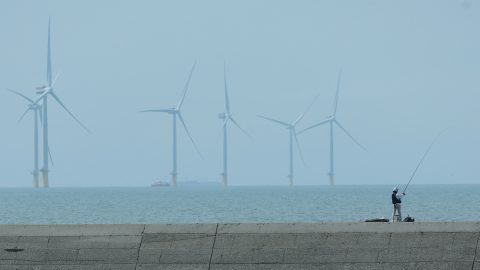 A man fishes near a wind farm in Yunlin County on March 4. (Photo: Ann Wang/Reuters)