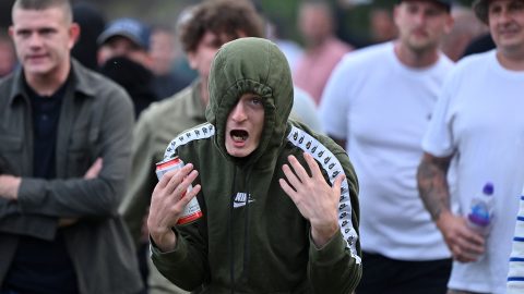 A protester gestures at riot police as clashes erupt in Bristol on August 3, 2024, during unrest in several English towns and cities following a mass stabbing in Southport that killed three young girls. (Photo: Justin Tallis/AFP)